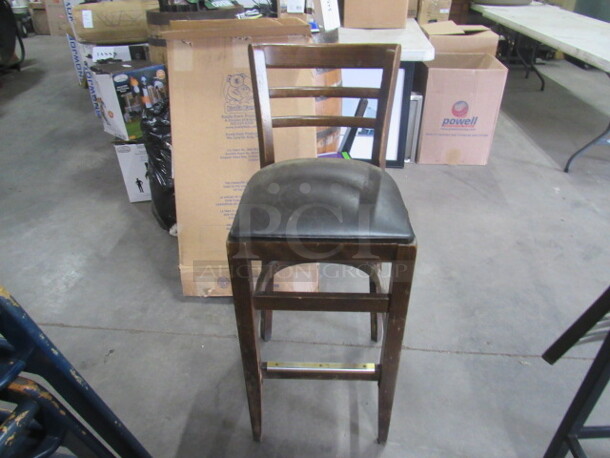 One Wooden Bar Height Chair With A Black Cushioned Seat.