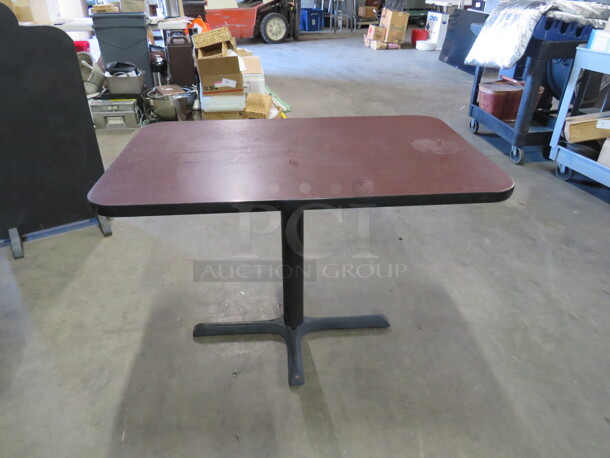 One Brown Laminate Table Top On A Pedestal Base. 42X26X29