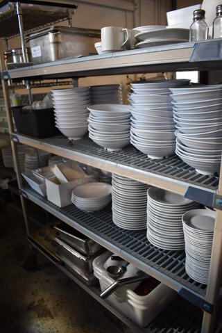 ALL ONE MONEY! Lot of Contents of Shelving Unit Including Stainless Steel Drop In Bins, Bowls, Plates, Bus Bins and Muffin Baking Pans. Does Not Include Shelving Unit. 