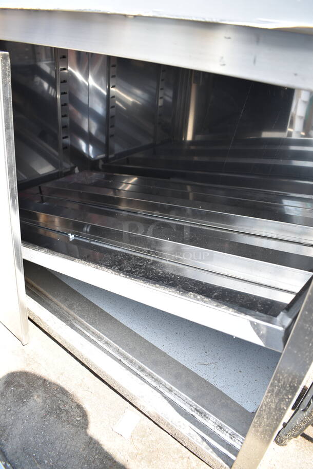 BRAND NEW SCRATCH AND DENT! Regency 600EBT3048D 30" x 48" 16 Gauge Type 304 Stainless Steel Enclosed Base Table with Sliding Doors and Adjustable Midshelf - Image 4 of 7