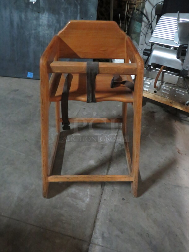 One Wooden High Chair With Safety Straps.