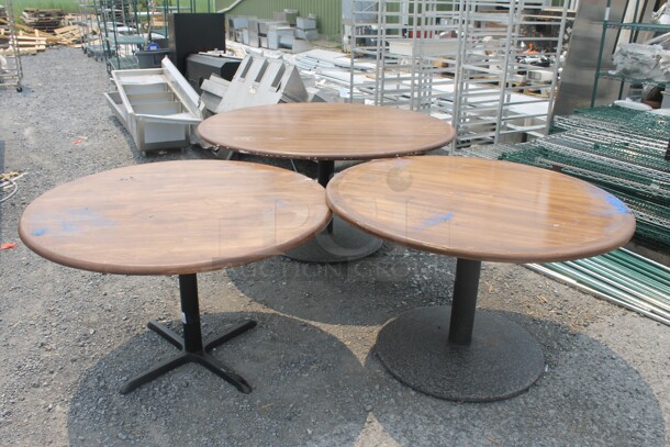 3 Round Wood Style Circular Tables on Black Bases. 3 Times Your Bid! Cosmetic Condition May Vary. 60x60x29.5 And 46.5x46.5x28.5