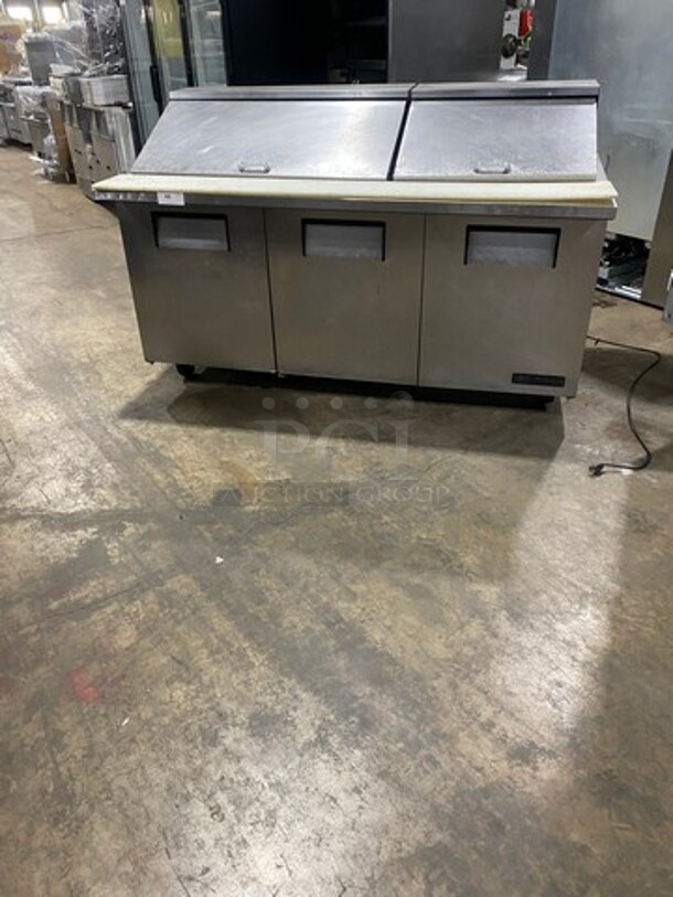 True Commercial Refrigerated Sandwich Prep Table! With Commercial Cutting Board! With 3 Door Storage Space Underneath! Poly Coated Racks! All Stainless Steel! On Casters! Model: TSSU7230MBST SN: 14451332 115V 60HZ 1 Phase