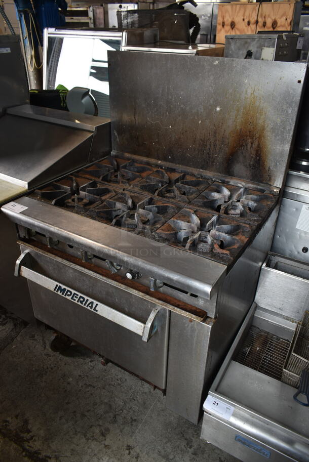 Imperial Stainless Steel Commercial Natural Gas Powered 6 Burner Range w/ Oven and Back Splash on Commercial Casters.