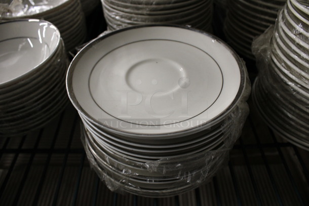 24 White Ceramic Saucers w/ Silver Colored Lines on Rim. 6x6x1. 24 Times Your Bid!