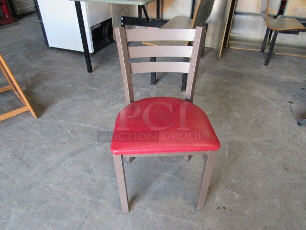 One Brown Metal Chair With Red Cushioned Seat. 