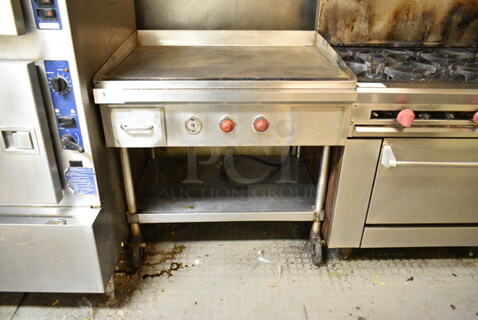 Stainless Steel Commercial Electric Powered Flat Top Griddle w/ Under Shelf on Commercial Casters. This Unit Was In Working Condition When the Restaurant Closed. (kitchen)