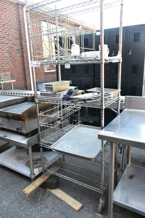 Chrome Finish 5 Tier Wire Shelving Unit on Commercial Casters w/ Contents Including Metal Baking Pans, Basket. Missing Wheel. BUYER MUST DISMANTLE. PCI CANNOT DISMANTLE FOR SHIPPING. PLEASE CONSIDER FREIGHT CHARGES. - Image 1 of 8