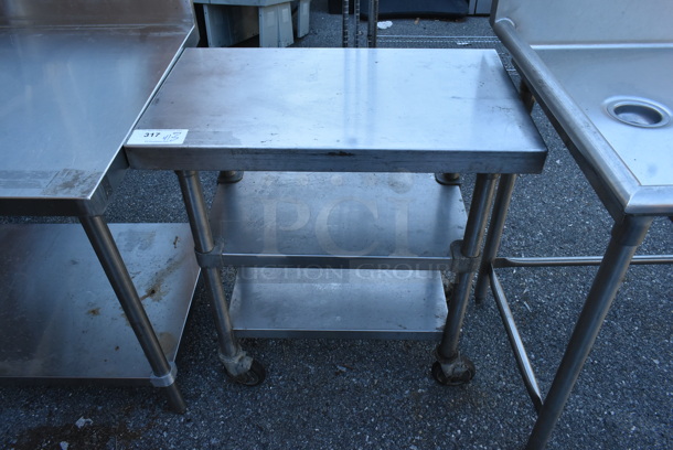 Stainless Steel Table w/ 2 Metal Under Shelves on Commercial Casters. 