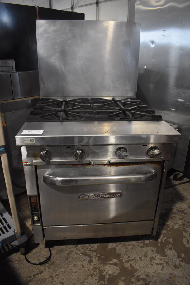 Southbend Commercial Stainless Steel Natural Gas Powered Oven With 4 Gas Burners and Stainless Steel Racks on Commercial Caster.  - Image 1 of 8