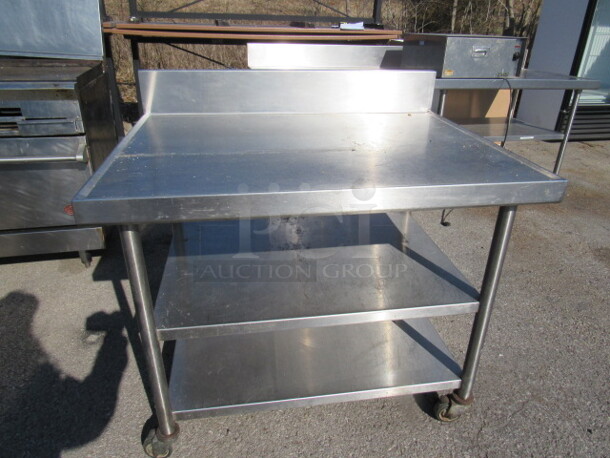 One Stainless Steel Table With 2 Stainless Steel Under Shelves, And Back Splash, On Casters. 42X32X40