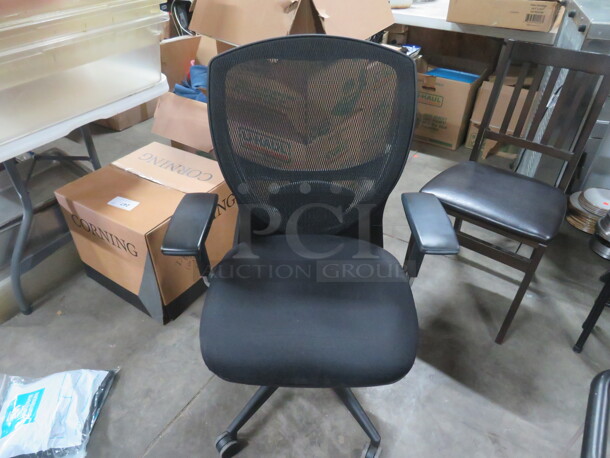 One Black Office Chair With Mesh Back On Casters.