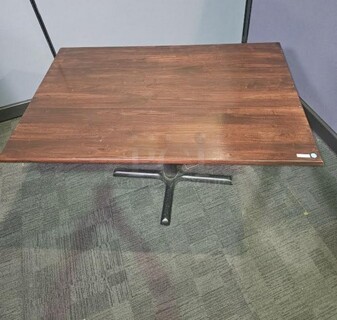 Restaurant style table with a black metal base and a dark grained wooden top. A solid table in good condition! Some scratching on base that can be cleaned up. 29” H x 48” W x 29.5” D.  

 