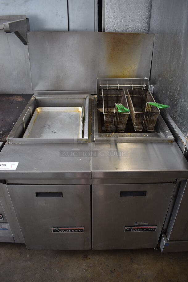 Garland M35SS Stainless Steel Commercial Natural Gas Powered Deep Fat Fryer w/ Left Side Dumping Station  and 2 Metal Fry Baskets on Commercial Casters. 34x43x51.5