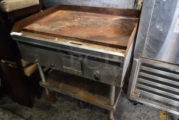 Lang Stainless Steel Commercial Natural Gas Powered Flat Top Griddle w/ Metal Under Shelf on Commercial Casters. 
