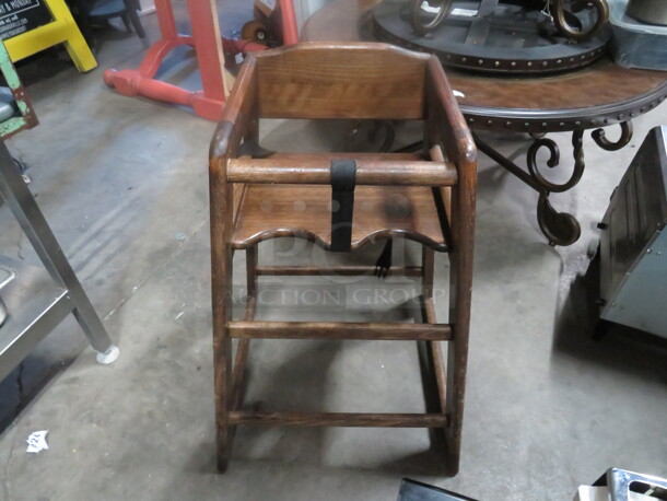 One Wooden High Chair With Safety Straps.