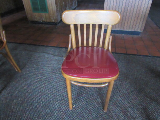 Wooden Chair With A Red Cushioned Seat. 4XBID.