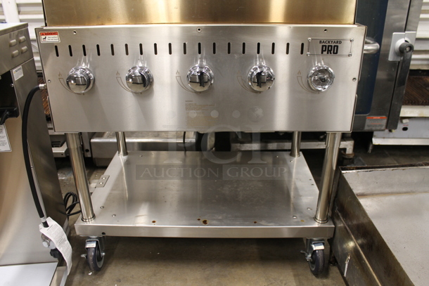 LIKE NEW! 2022 Backyard Pro 554LPG36 Stainless Steel Commercial Propane Gas Powered Outdoor Grill w/ Brick Oven Attachment and Under Shelf on Commercial Casters. Stock Picture Used as Gallery. Tested and Working! - Image 4 of 7