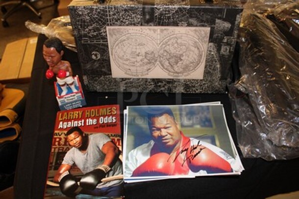 Black Hard Case w/ Map Design and Contents Including Autographed Larry Holmes Against the Odds Book, Autographed Larry Holmes Bobblehead and 9 Signed Larry Holmes Photographs.