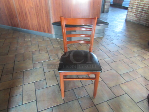 Wooden Chair With A Black Cushioned Seat. 4XBID.