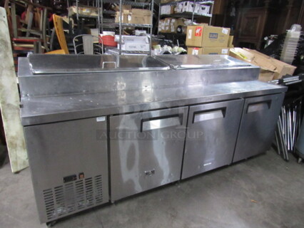 One Stainless Steel  Kelvinator 3 Door Refrigerated Prep Table With 3 Racks On Casters. Model# KCPT92.12. 92X33X42