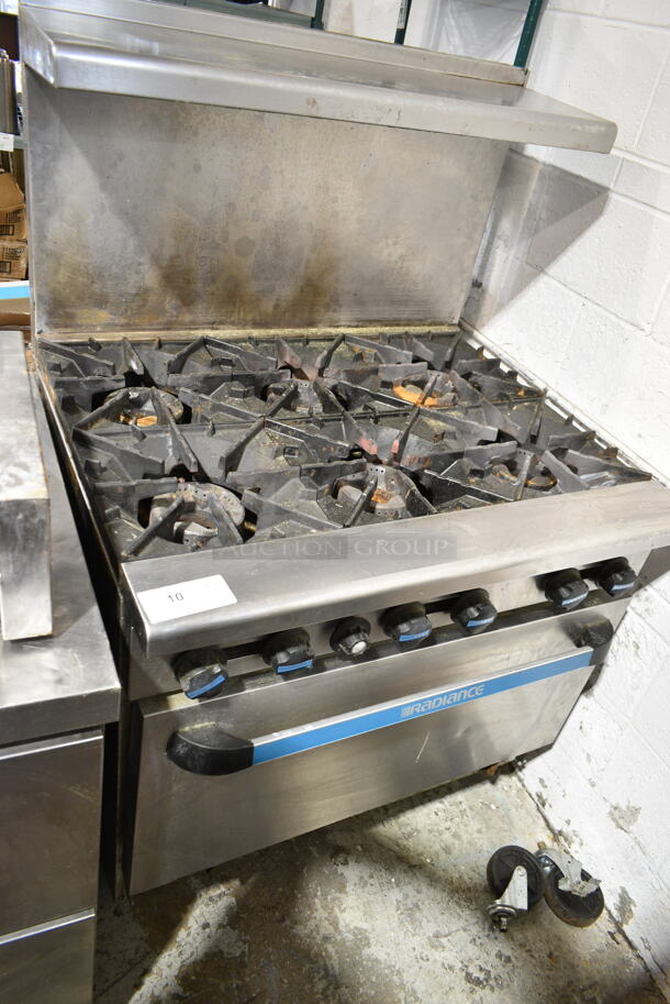 Radiance Stainless Steel Commercial Natural Gas Powered 6 Burner Range w/ Oven, Over Shelf and Back Splash on Commercial Casters. 2 Casters Need To Be Reattached. - Image 1 of 5