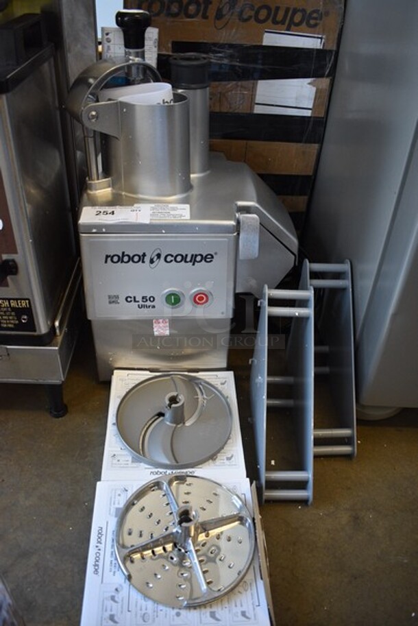 BRAND NEW IN BOX! Robot Coupe Model CL50 U Series E Metal Commercial Countertop Continuous Feed Food Processor w/ 2 Gray Poly Blade Holders, 28058 Grater Blade and 28064W Slicing Blade. 120 Volts, 1 Phase. 14x12x24. Tested and Working!