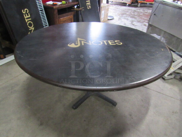 One 60 Inch Round Black Table Top With The NOTES Logo  On A Pedestal Base. 60X60X30