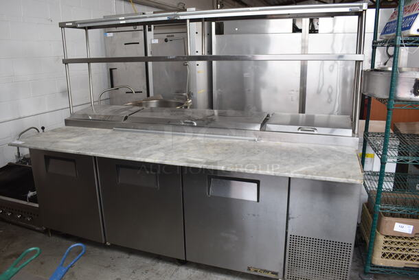 True TPP-93 Commercial Stainless Steel Pizza Prep Table With 2 Over shelves And Steel Racks on Commercial Casters. 115V/ 1 Phase. Tested And Working