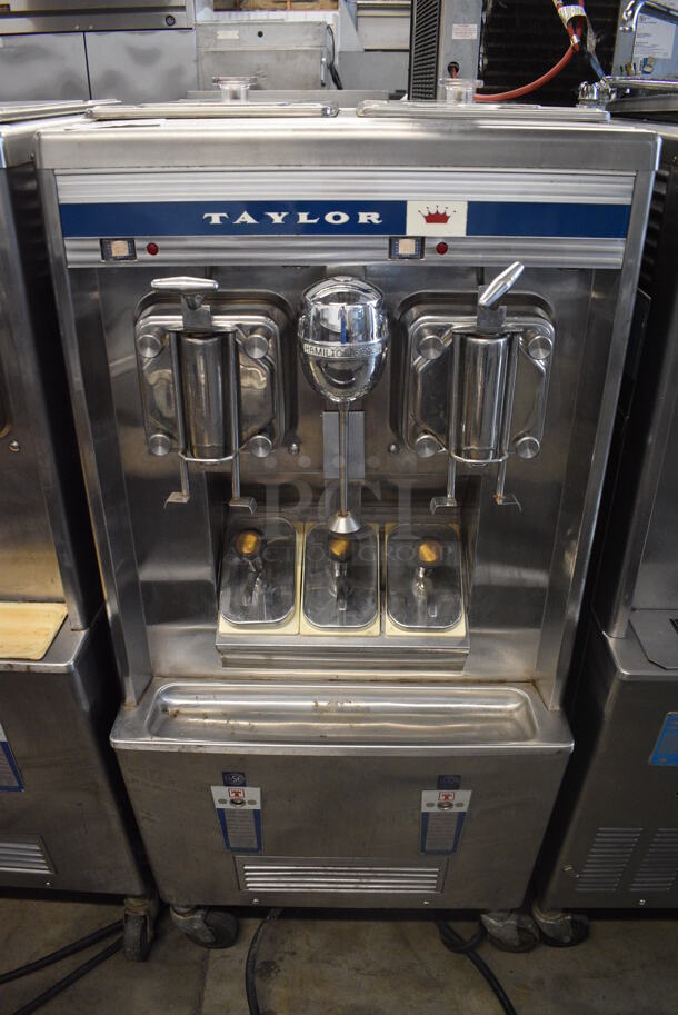 Taylor Model B444-33 Stainless Steel Commercial Floor Style Air Cooled 2 Head Shake Freezer Milkshake Machine w/ Center Drink Mixer on Commercial Casters. 208/220 Volts, 3 Phase. 26x34x60