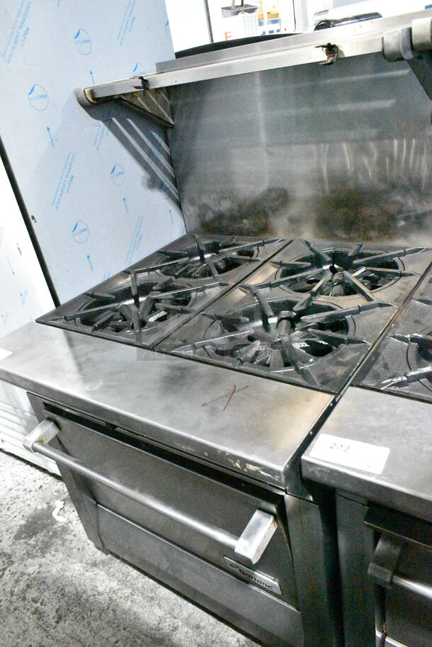 Garland M44R Stainless Steel Commercial Floor Style Natural Gas Powered 4 Burner Range w/ Oven, Over Shelf and Back Splash on Commercial Casters.  - Image 1 of 7