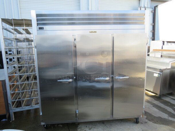 One Working Stainless Steel Traulsen 3 Door Refrigerator, With 9 Racks,  On Casters. Model# G30011. 115 Volt. 77X35X83.5. $9176.00.  - Image 2 of 3