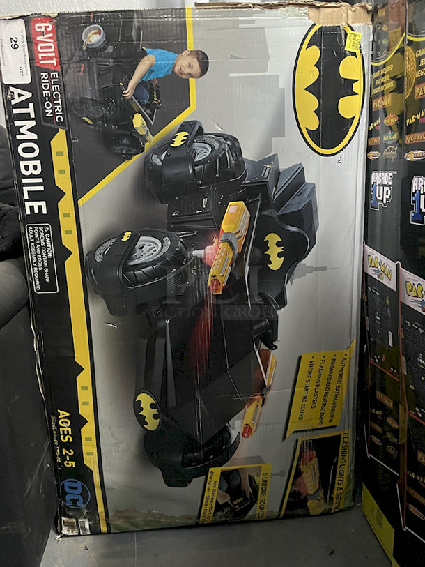 NEW/NEVER USED - DC Batmobile Car, Model: EC-1710-GC – Authentic Batman Design6v Electric Ride-On ; Forward & Reverse Drive; Flashing Blasters; Engine Starting Sound; (5) Unique Sounds: Fire Blasters – Start Up – Afterburner – Shield – Night Vision. Top of box is open, all parts appear to be in the box in original packaging.  - Image 1 of 3