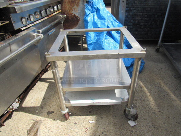 One NEW Stainless Steel Equipment Table With 19X16.5 Top Cut Out, And 2 Stainless Under Shelves On Casters. 24X21X26