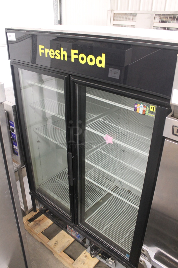 2012 True GDM-49 Commercial Two-Door Black Merchandiser Cooler With Polycoated Shelves. 115V, 1 Phase. Missing Bottom Cover. Tested and Powers On But Does Not Get Cold
