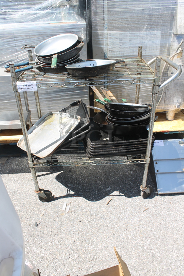 Chrome Finish 2 Tier Wire Shelving Unit on Commercial Casters w/ Contents Including Skillets. BUYER MUST DISMANTLE. PCI CANNOT DISMANTLE FOR SHIPPING. PLEASE CONSIDER FREIGHT CHARGES.