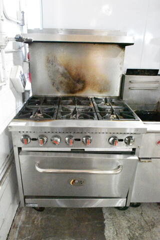 Cooking Performance Group CPG 351S36N Stainless Steel Commercial Natural Gas Powered 6 Burner Range w/ Oven, Over Shelf and Back Splash on Commercial Casters. 210,000 BTU. 