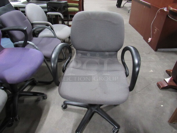 One Gray Cushioned Office Chair On Casters.