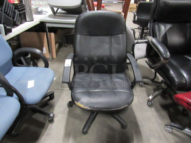 One Black Pleather Office Chair On Casters.