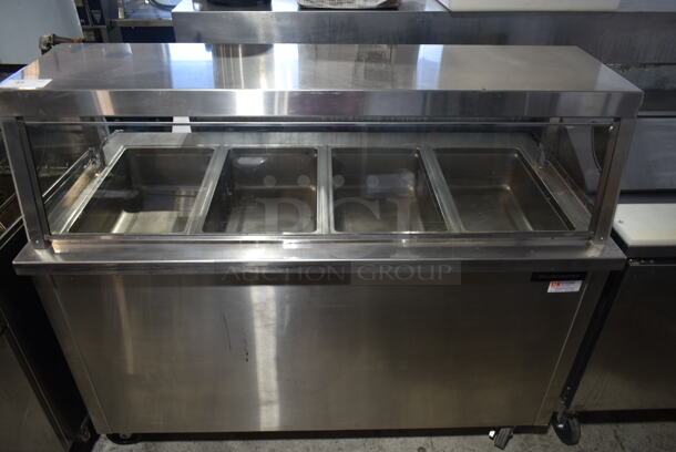 Delfield SH4-NU Stainless Steel Commercial Electric Powered 4 Bay Steam Table w/ Sneeze Guard on Commercial Casters. 120/208-240 Volts, 1 Phase. 