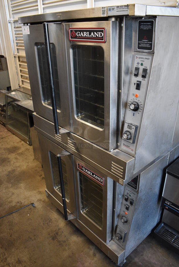 2 LATE MODEL Garland Master 200 Stainless Steel Commercial Electric Powered Full Size Convection Ovens w/ View Through Doors, Metal Oven Racks and Thermostatic Controls on Commercial Casters. 208 Volts, 3 Phase. 38x38x70. 2 Times Your Bid!