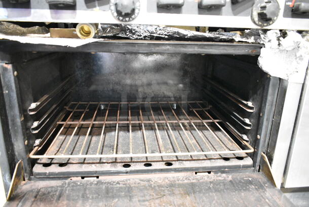Garland Metal Commercial Natural Gas Powered 6 Burner Range w/ Flat Top Griddle, 2 Ovens, Back Splash and Over Shelf on Commercial Casters.  - Image 4 of 11