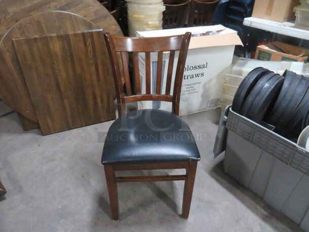 Wooden Chair With Black Cushioned Seat. Cushions Are Fair Condition. Some With Rips, Some Are Good. 4XBID