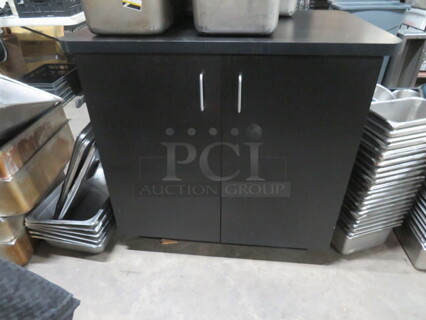 One 2 Door Black Laminate Cabinet With 1 Shelf. 36X24X34