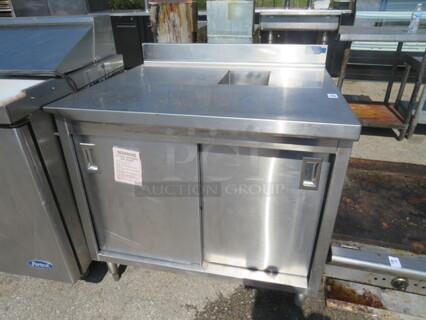 One Stainless Steel WorkTop Table With 2 Sliding Doors, Back Splash, Under Storage And An 8X12 Cutout. 38X34X38