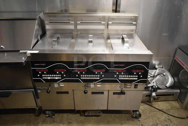 2017 Henny Penny EEG-243 FFFX PH Stainless Steel Commercial Floor Style Natural Gas Powered 3 Bay Deep Fat Fryer w/ 3 Lids on Commercial Casters. 225,000 Btu. 