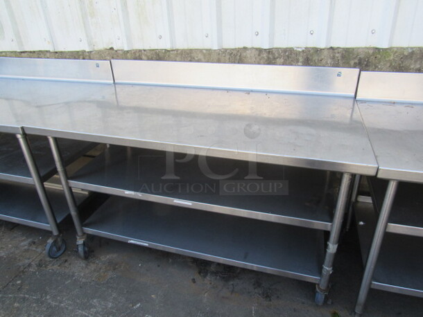 One Stainless Steel Table With 2 Stainless Steel Under Shelves, Back Splash On Commercial Casters. 60X21X40.