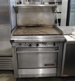Garland M47R Stainless Steel Commercial Natural Gas Powered Flat Top Griddle w/ Oven, Over Shelf and Back Splash.
