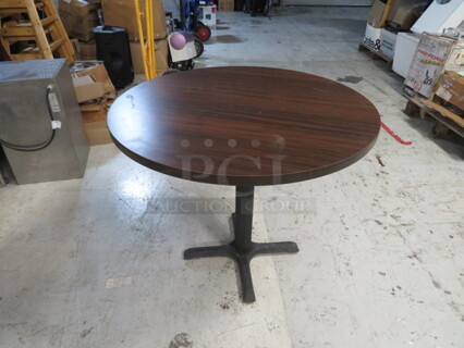 One Brown Laminate Table Top On A Pedestal Base. 36X36X29