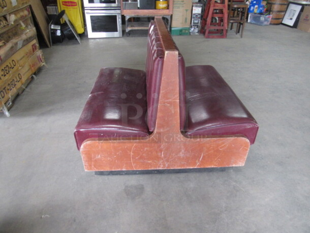 One Wooden Double Sided Booth With Burgundy Cushioned Seat And Back.